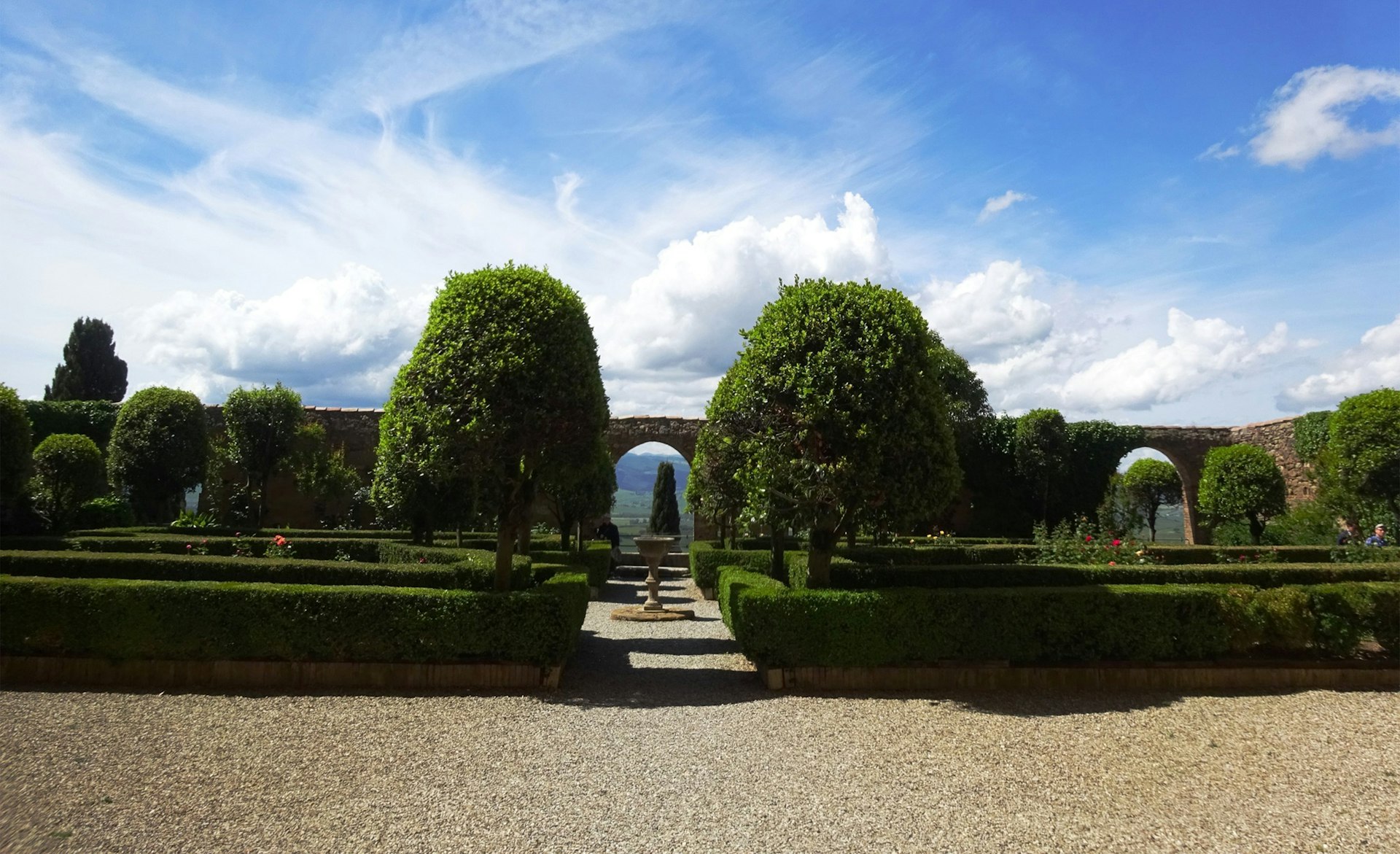 Stone garden path with fountain and manicured landscaping