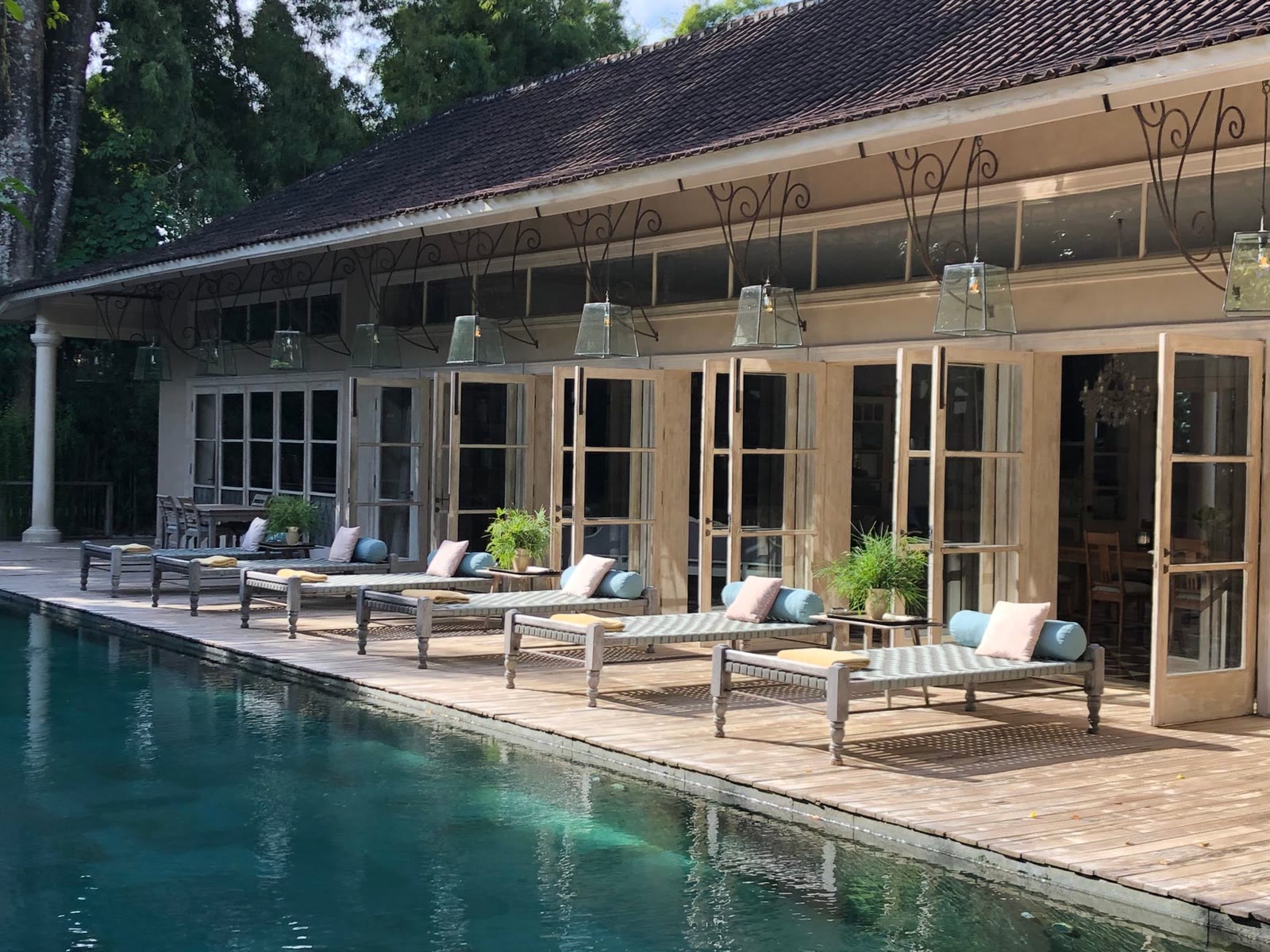 Stone poolside deck with loungers beside a villa